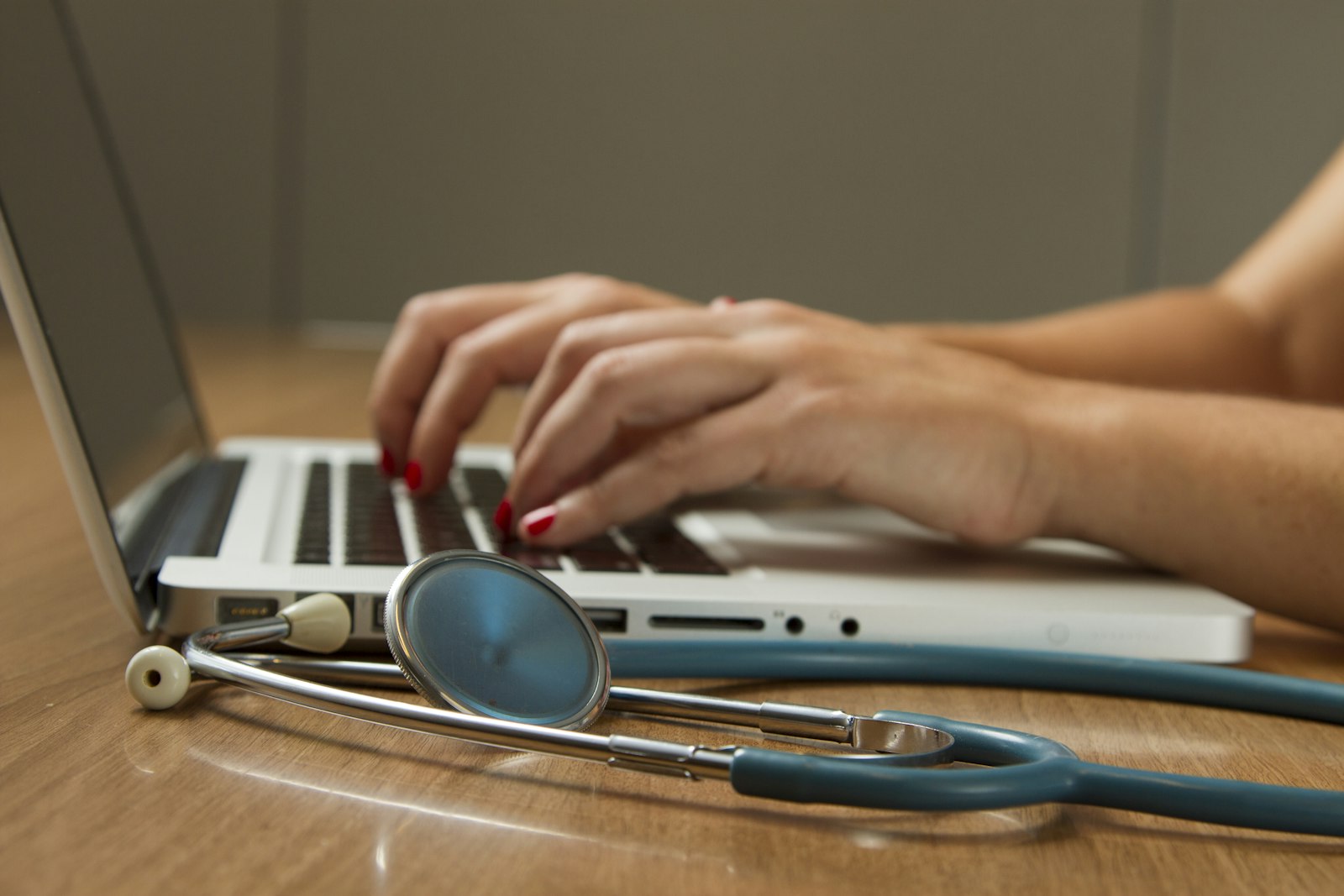 A physician’s stethoscope resting beside a laptop during professional case review.
